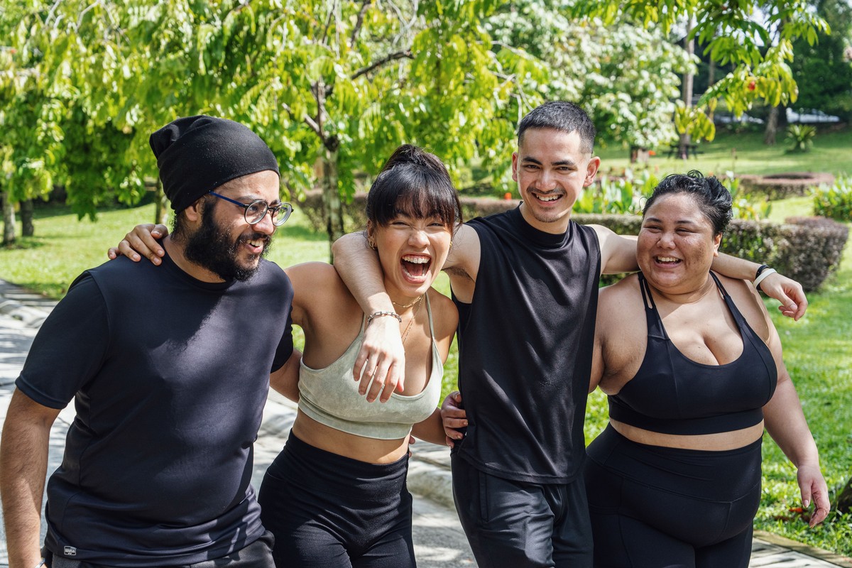 Friends laughing together during an outdoor fitness session
