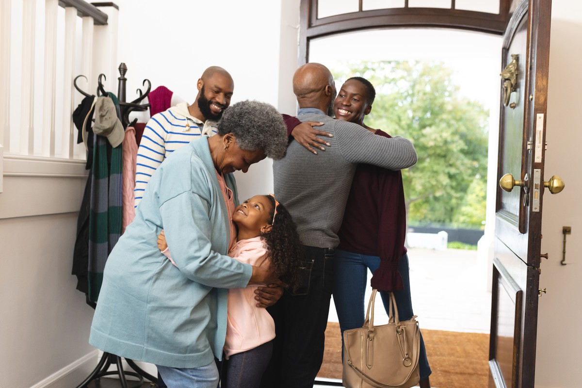 A multigenerational family hugging in a doorway
