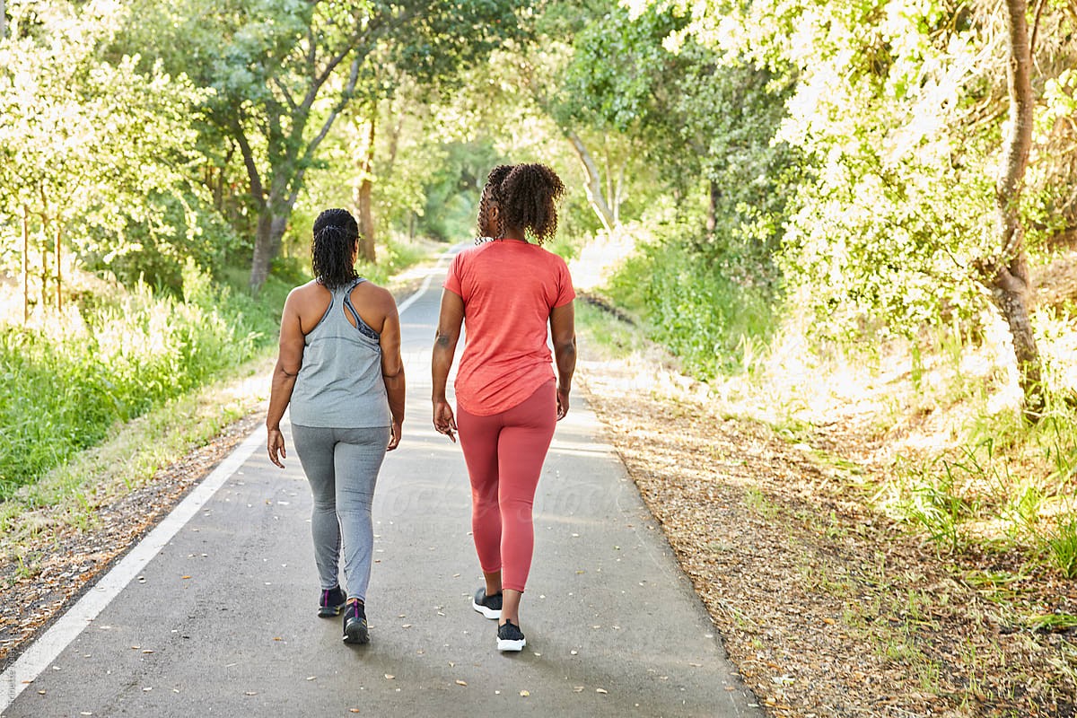 Two women walking together on an outdoor fitness trail